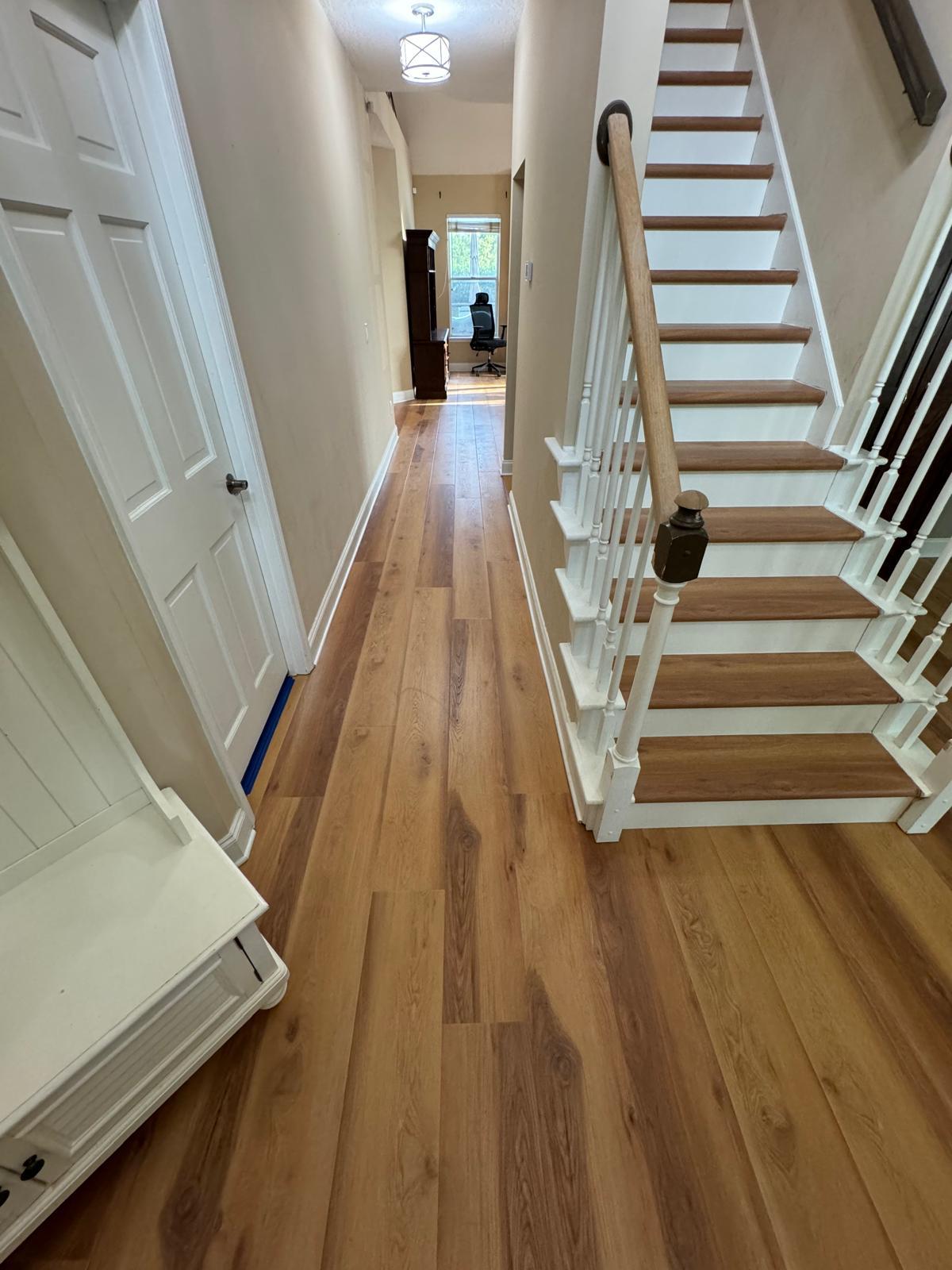 Warm oak plank hallway with matching stair treads in an Orlando home