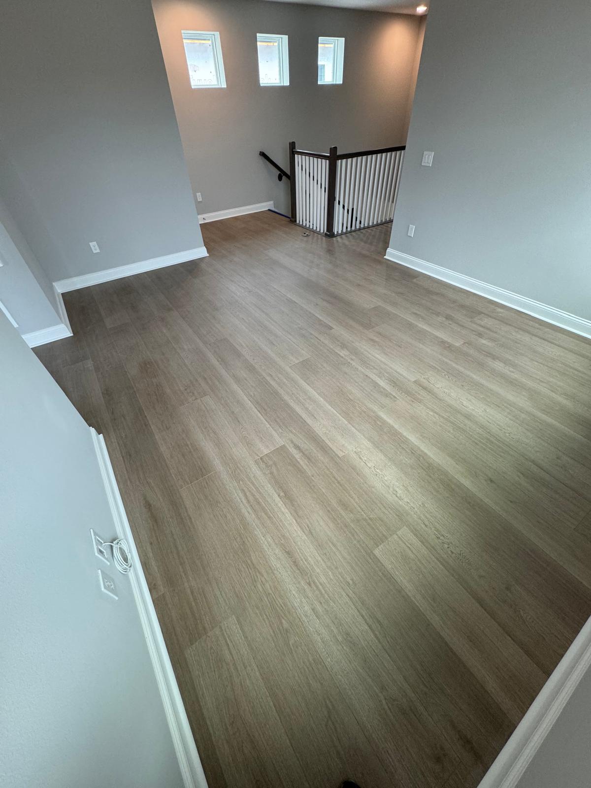 Spacious sunlit Orlando living room with warm greige wood-look plank flooring