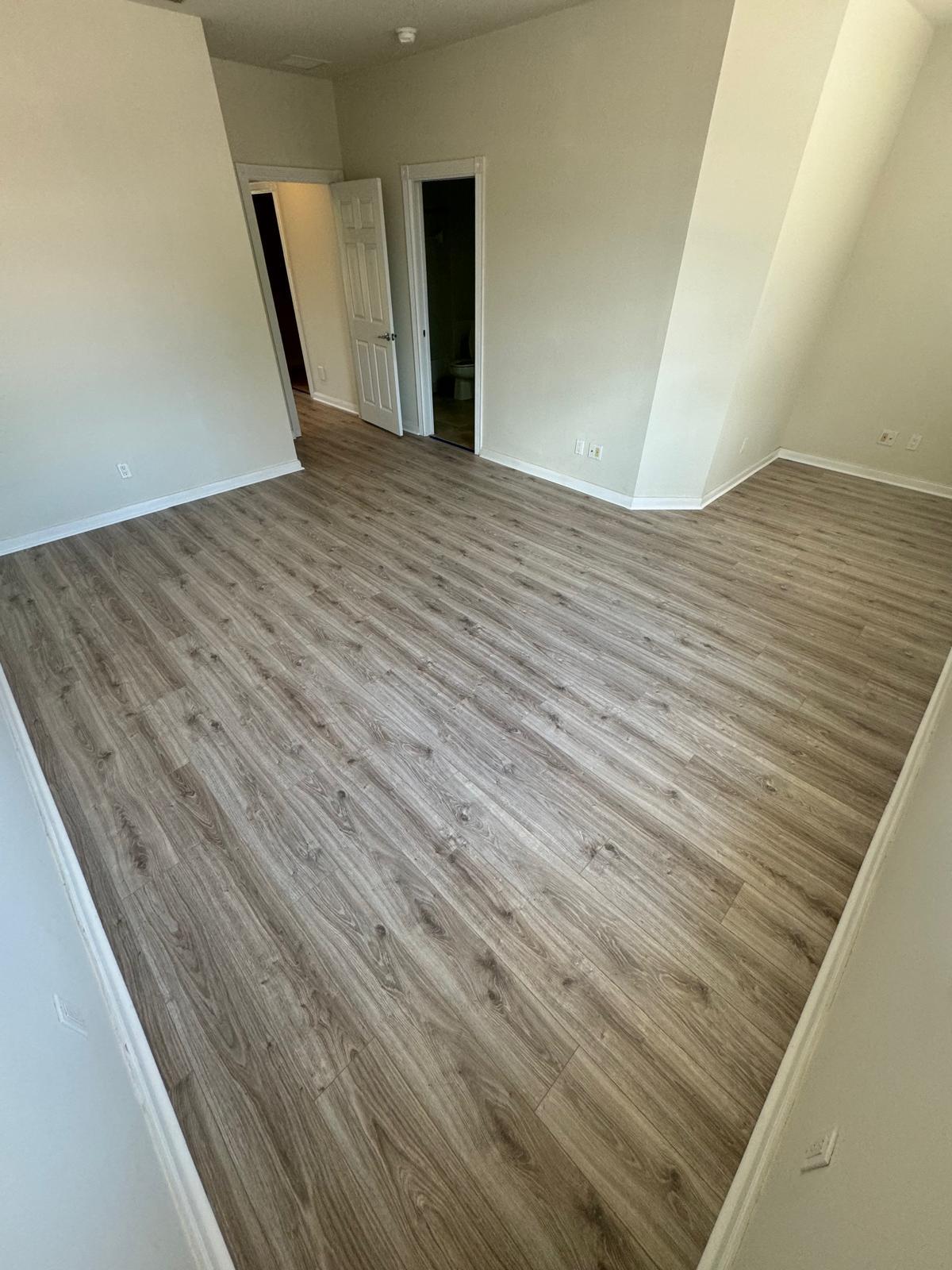 Greige luxury vinyl plank flooring in a sunlit room